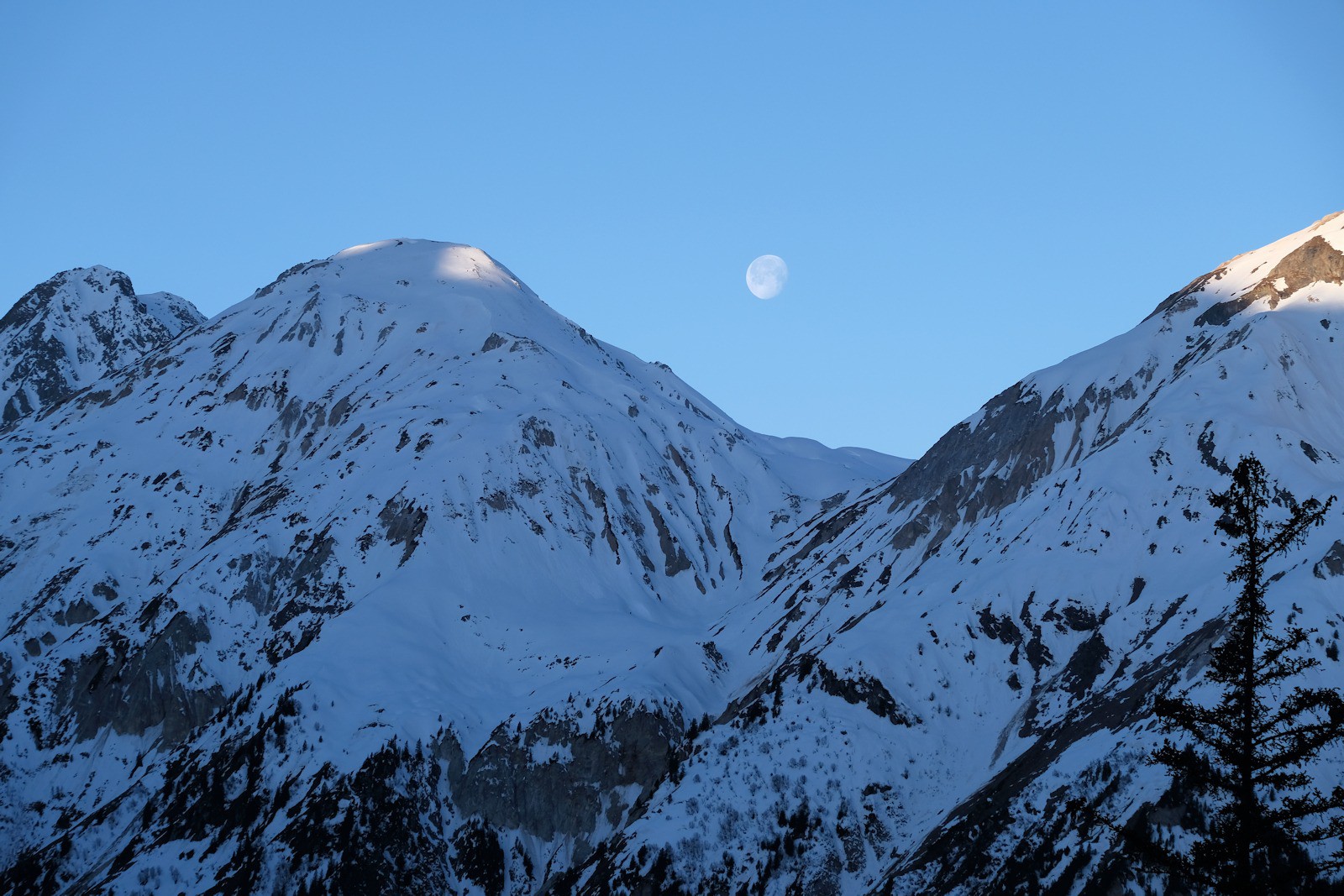 Le soleil se lève sur le petit Mont-Blanc alors que la lune est encore présente.