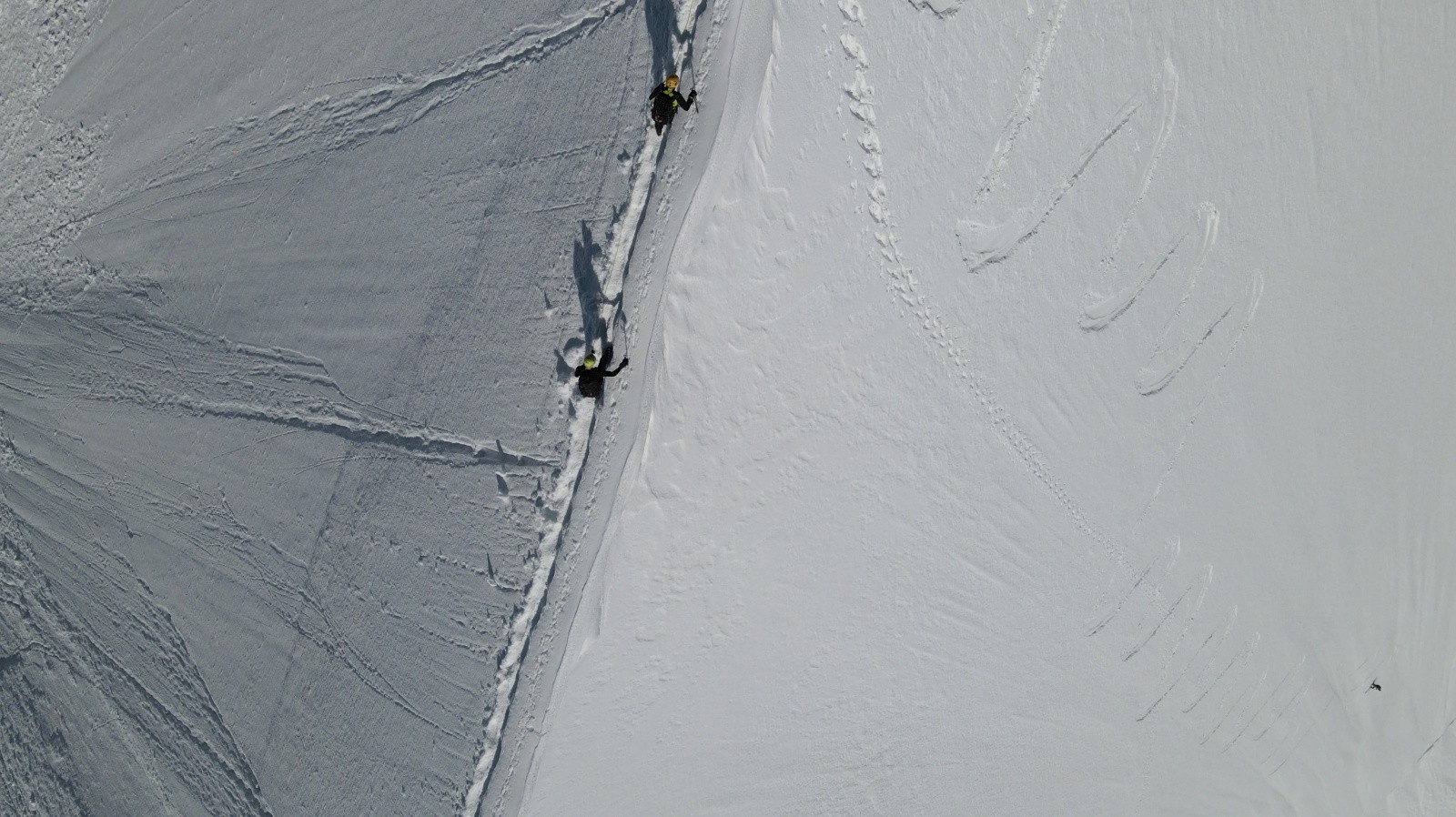 Perspective intéressante avec les alpinistes sur l'arête et le skieur loin en contrebas...