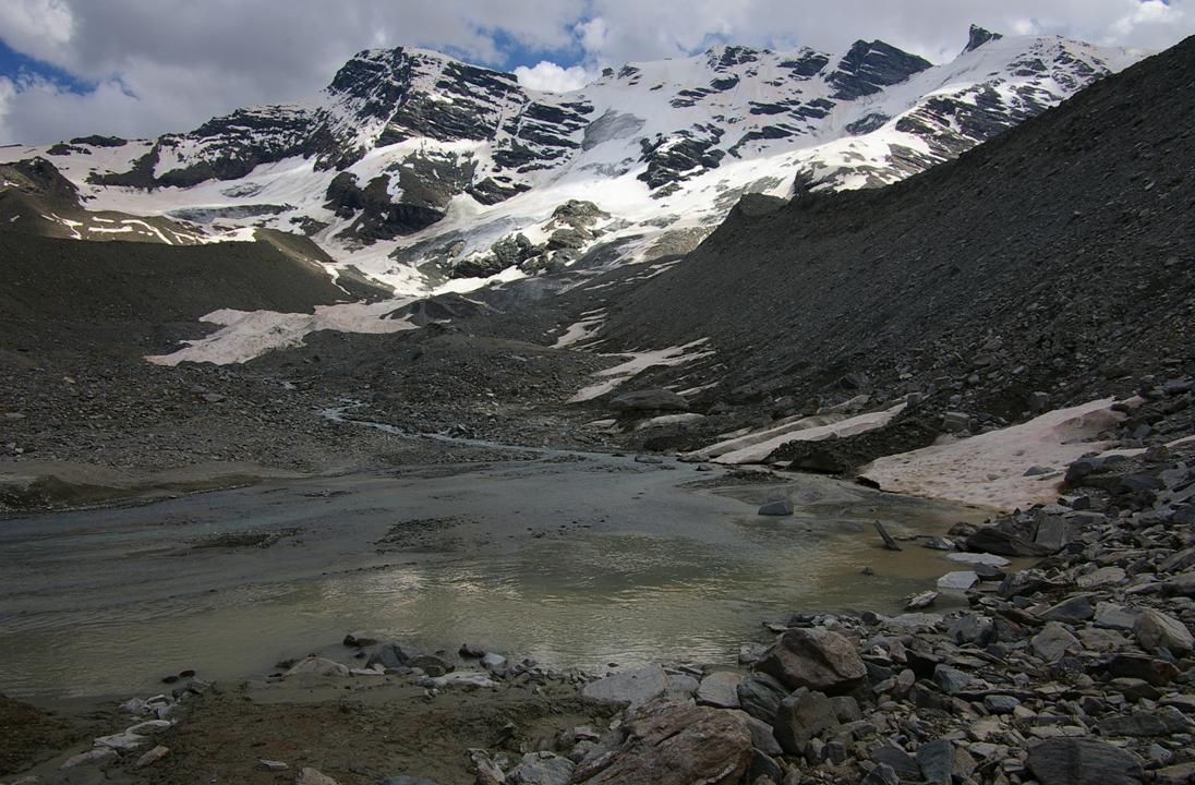 Le lac à 2602 : Exutoire du glacier d'Invergnau. A noter, le bivouac Ravelli se situe en léger surplomb à gauche du sommet de la grande moraine qui fait face au cliché, en rive droite du glacier.