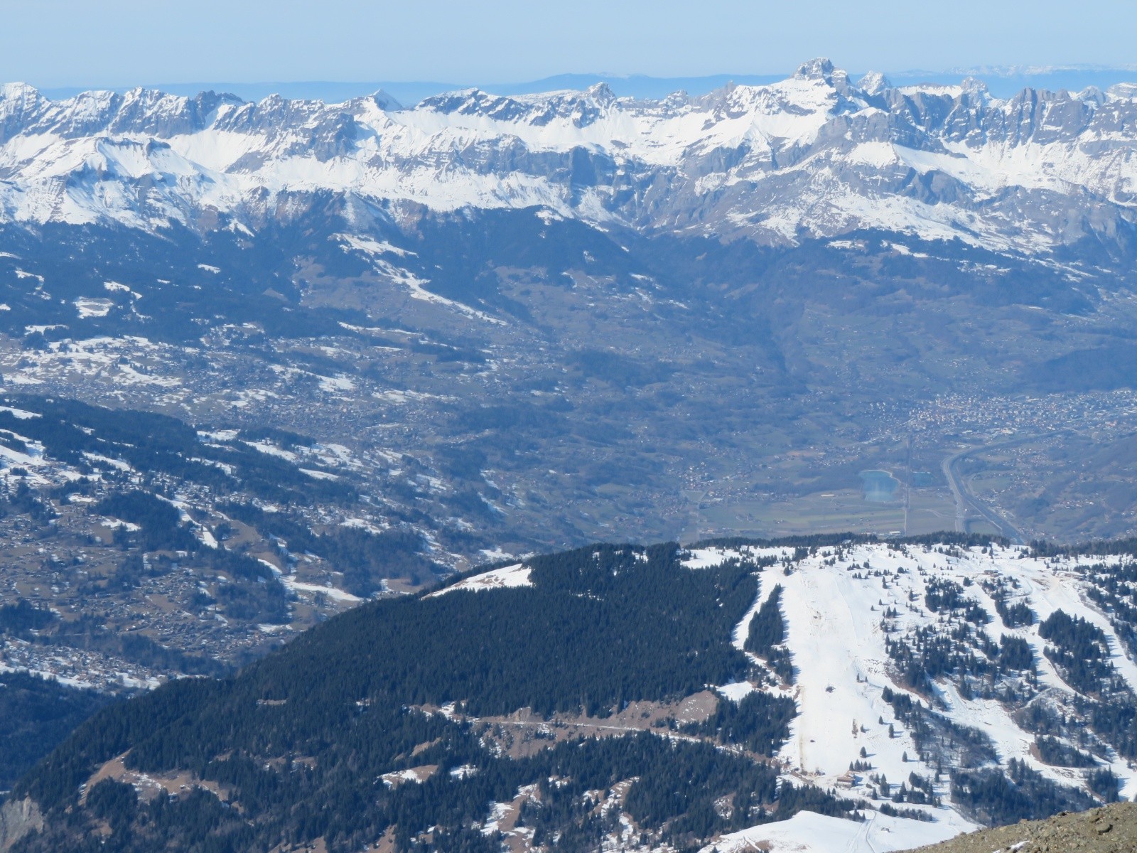 Pistes des Houches au premier plan. Lac de Passy et Sallanches en contrebas, chaîne des Aravis, avec la Pointe Percée.&nbsp;