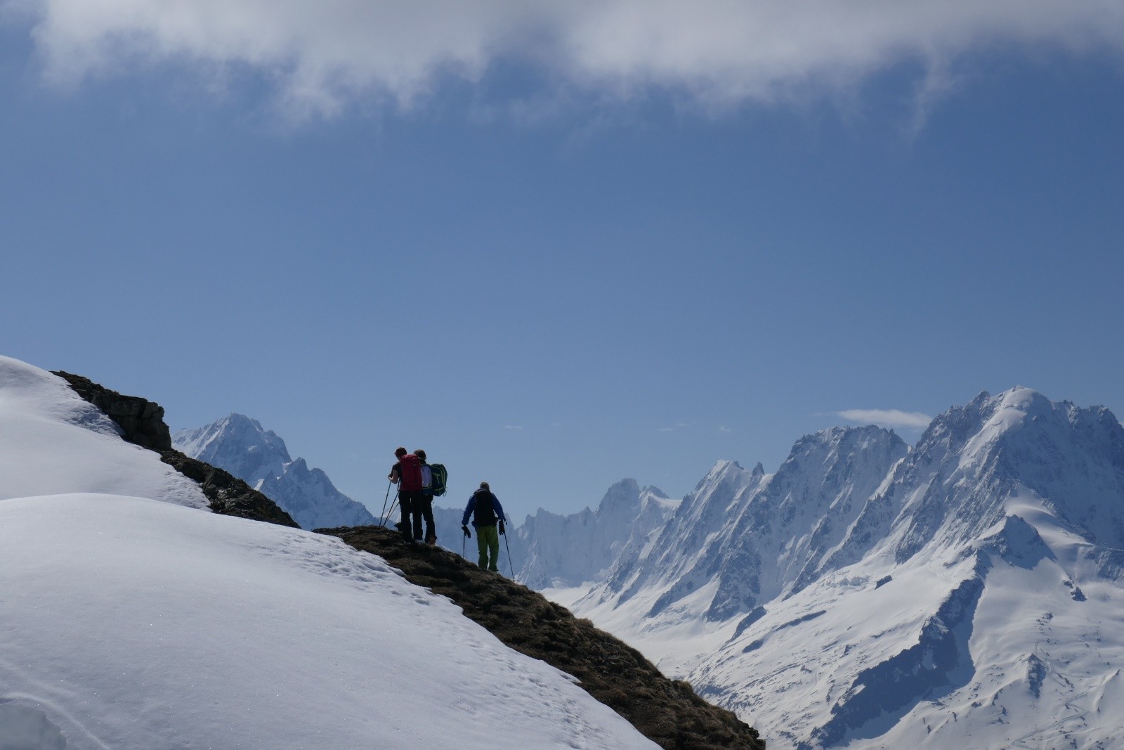 Trois personnes montent vers le sommet. Les faces nord du bassin d'Argentières sont bien enneigées.