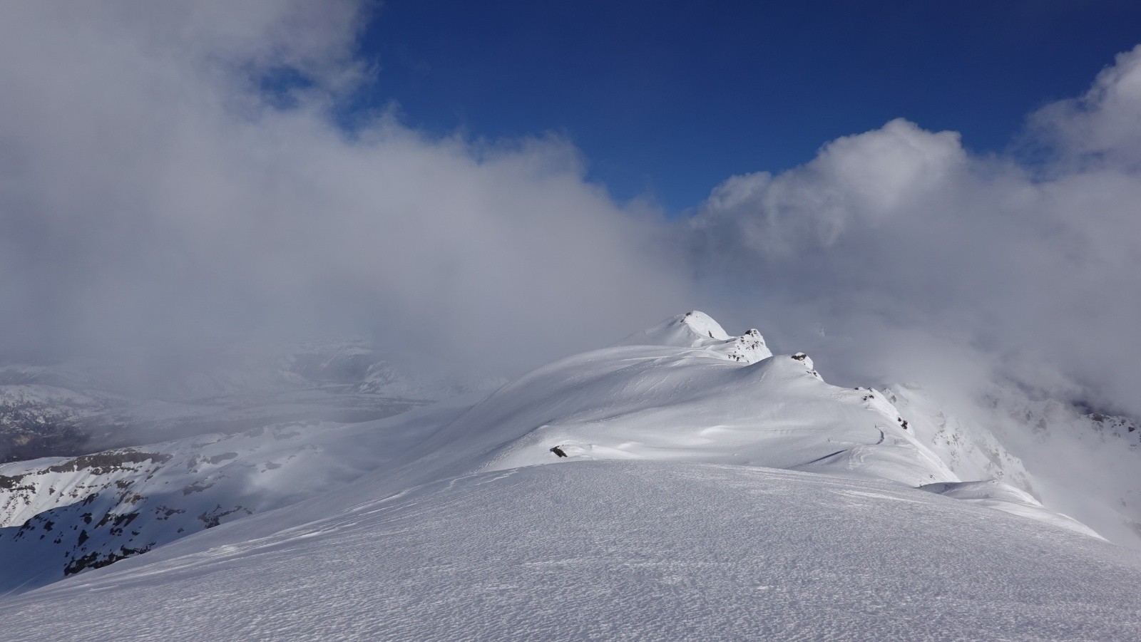 Le sommet sud entouré de nuages masquant le panorama sur le volcan Lanin