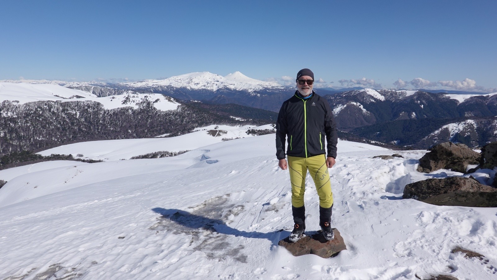 Didier au sommet sur fond de Sierra Nevada et volcan Llaima