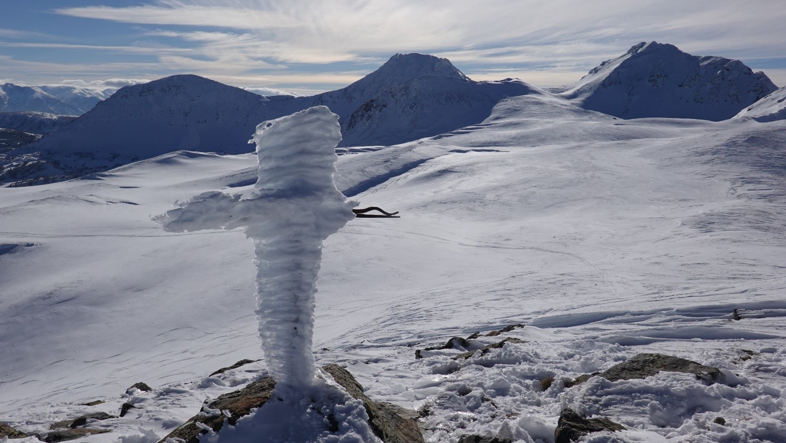 La croix sommitale en glace sur fond de Petit Péric, Puig Péric et Puig de la Porteille Gran