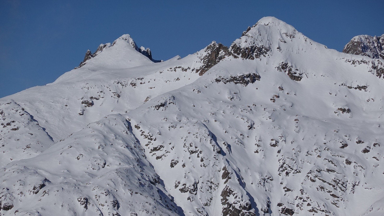 Panorama au téléobjectif sur la Cime Guilié avec du monde au sommet et la Tête de la Ruine