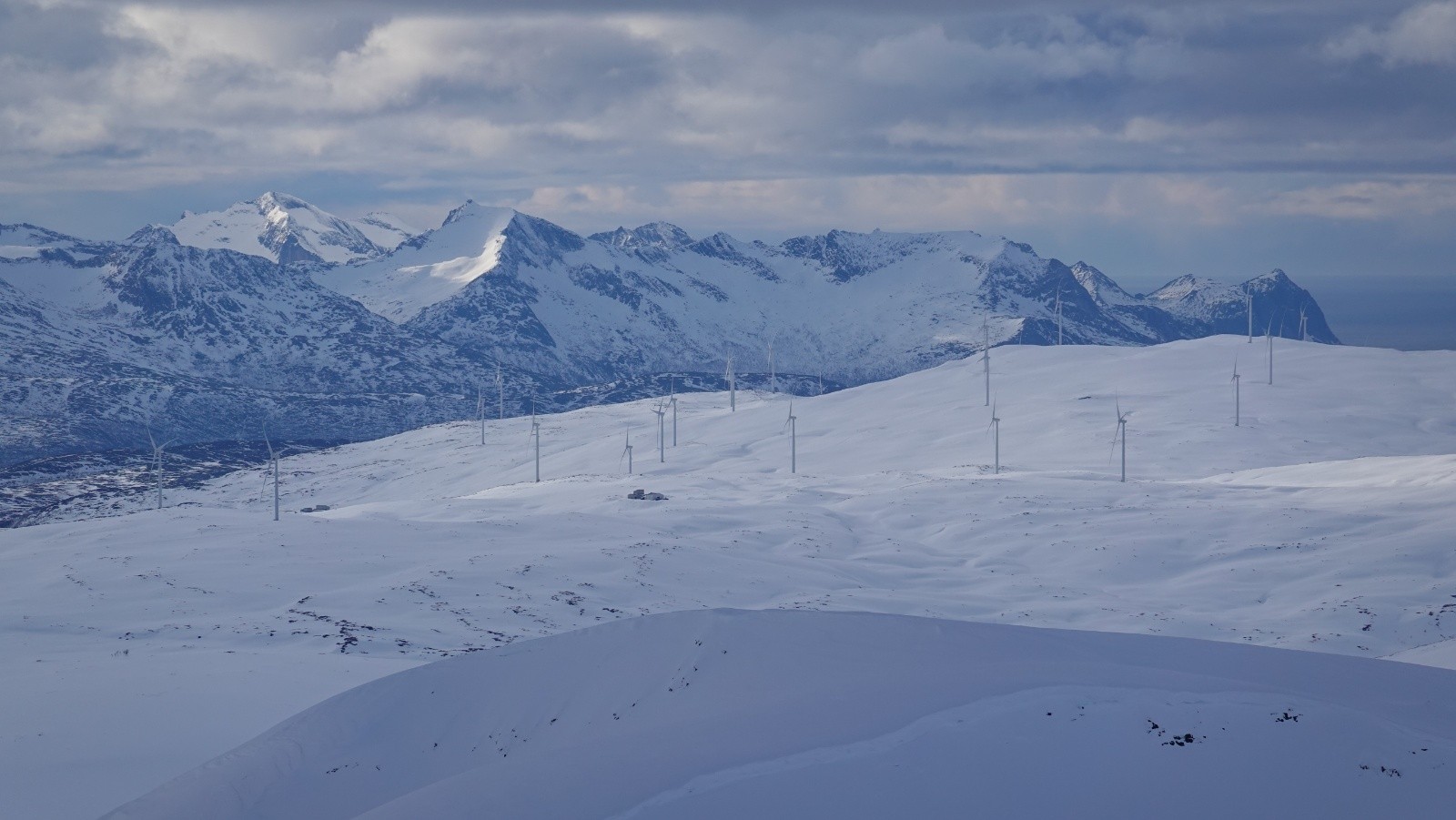 Panorama au téléobjectif sur une champ d'éoliennes en pleine montagne