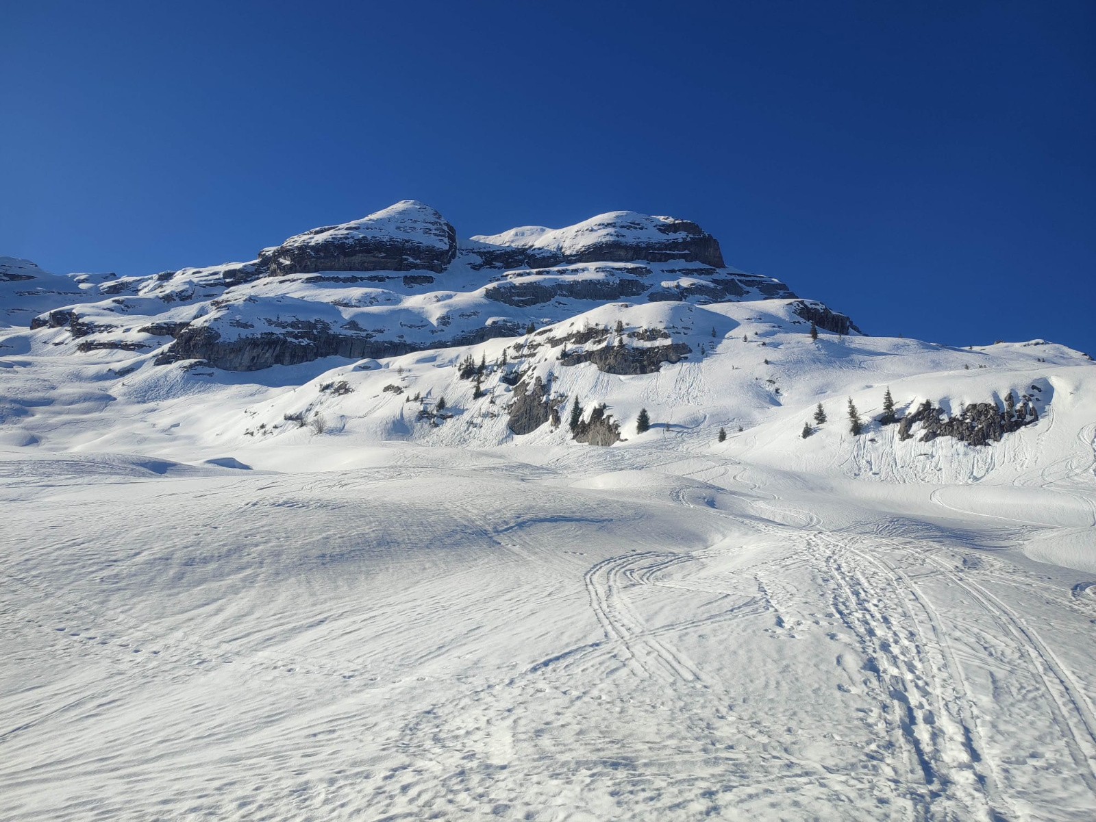 Vue sur la Croix de Fer et l'Aiguille d'Aujon. Boulettes de neige humide dans les rochers.
