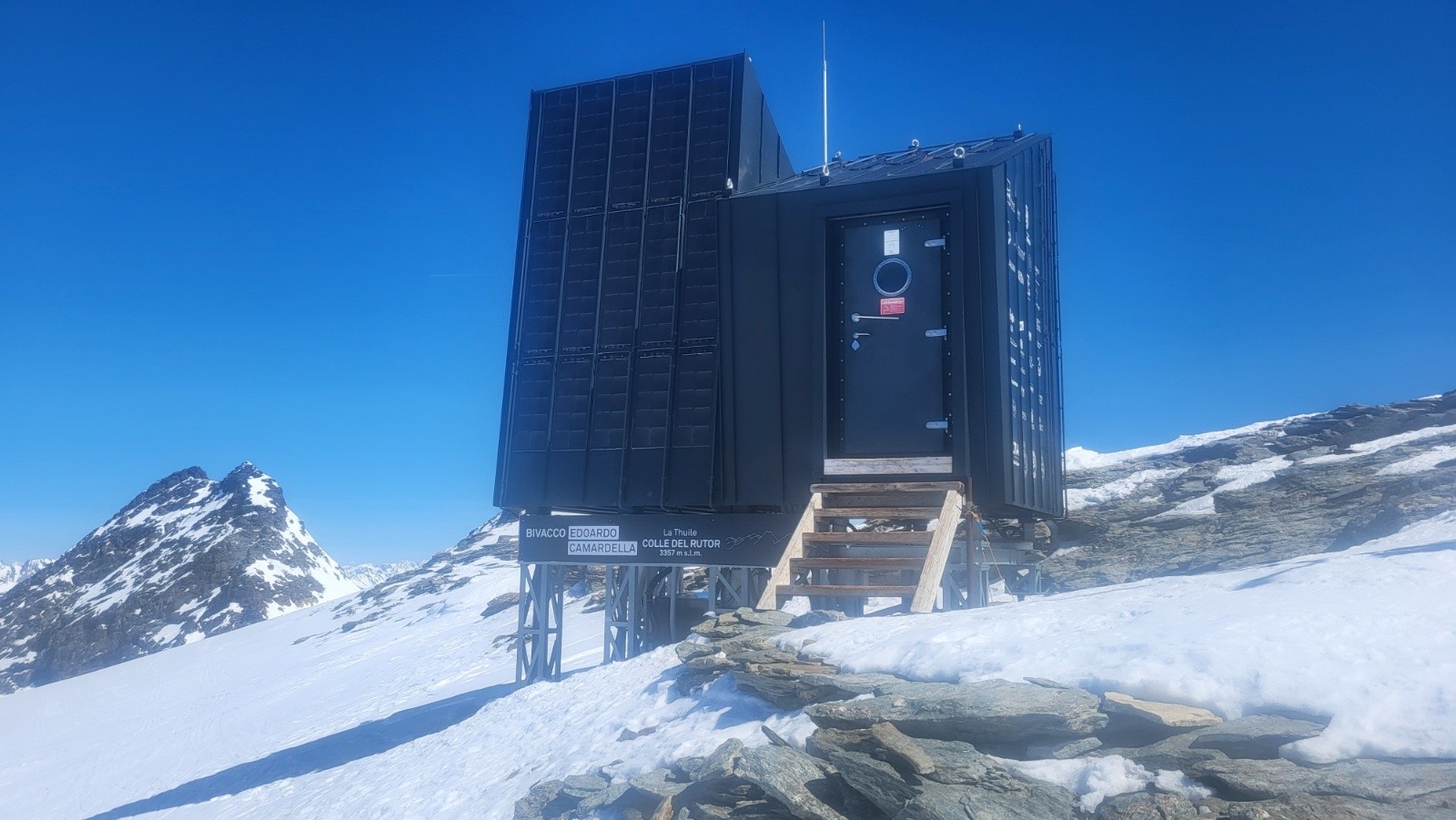 J2 Caméra sale donc photo floue. Bienvenu au bivacco Edoardo Camardella. 6 matelas. Fenêtre donnant sur le massif du Mont-Blanc. Prise USB et USB-C à côté de chaque matelas. Un balais.