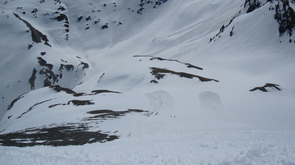 En plongée : La pente sous le sommet avec 2 randonneurs un peu tardifs
