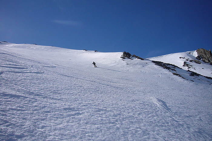 Sous le col allongé.