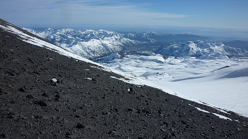 Fin d'ascension : La face Nord du volcan Chillan Viejo depuis le col à 3000m souvent sans neige en raison du vent. La valle de Las trancas en fond de photo