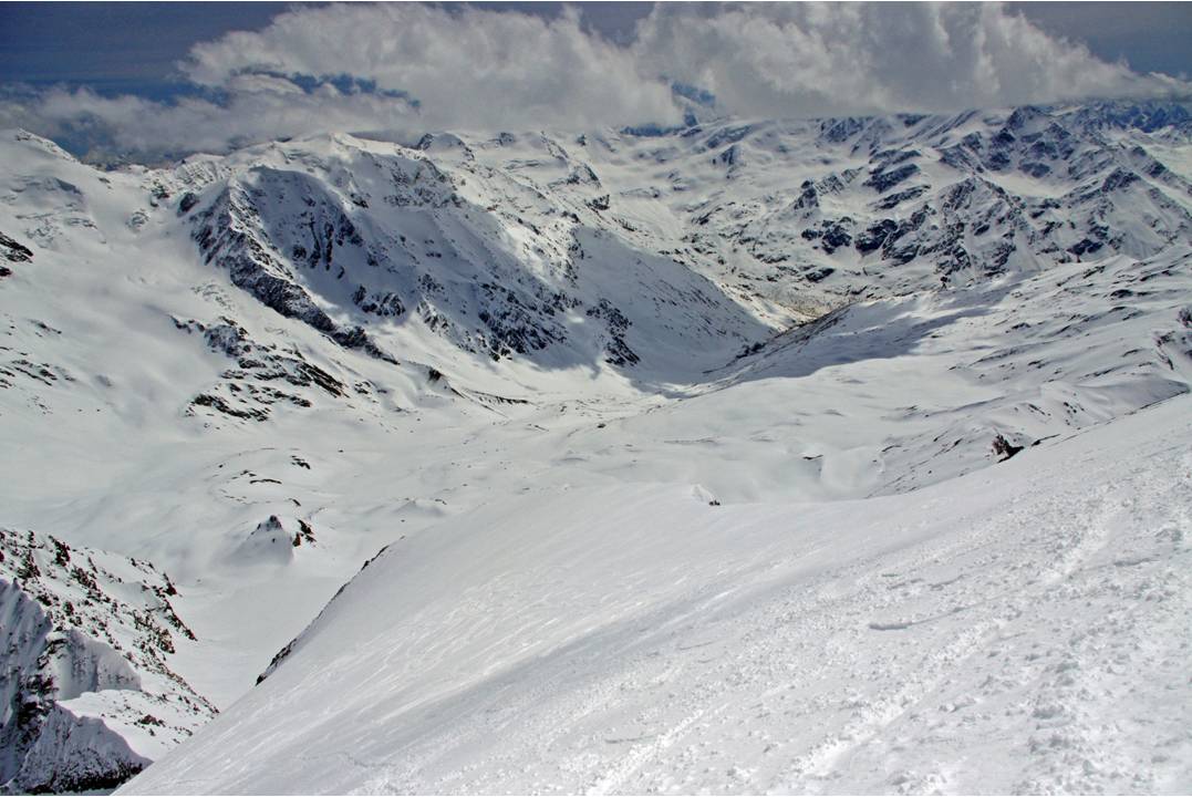 Pente supérieure du Zébru : Nous chaussons les skis, 100 mètres sous le sommet. La pente est éclairée. Les nuages du matin ont permis de la protéger d'un rayonnement trop important. La pente fuit, la neige offre un grip profond, resistant, plein de s
