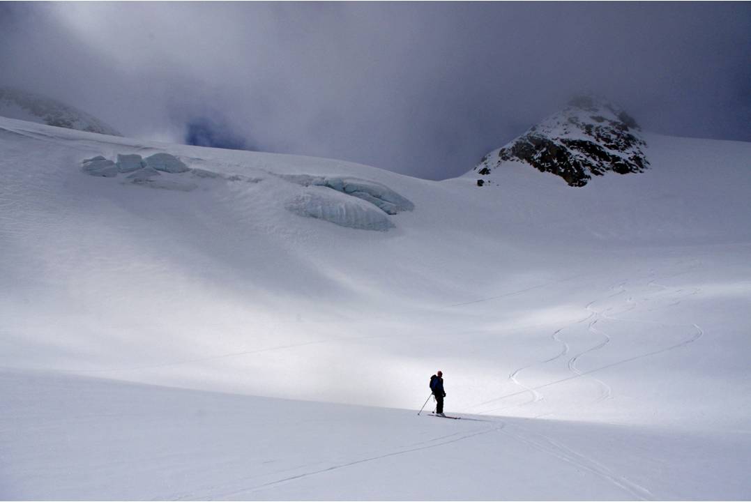 Descente ouatée : La descente du glacier de Gébroulaz s'effectue dans la ouate nuageuse: des passages sombres blanc sur blanc, et des trouées de soleil... le lieu est grandiose...