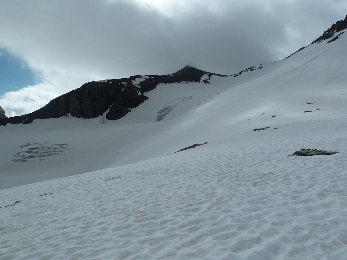 Glacier des sources de l'Isère : vue d'ensemble de la face N de la Grande Aiguille Rousse. La collective du CAI dans le haut du glacier, l'unique et bien sympathique rencontre de la journée.