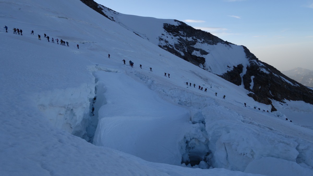 Belle procession d'alpinistes sur glacier crevassé