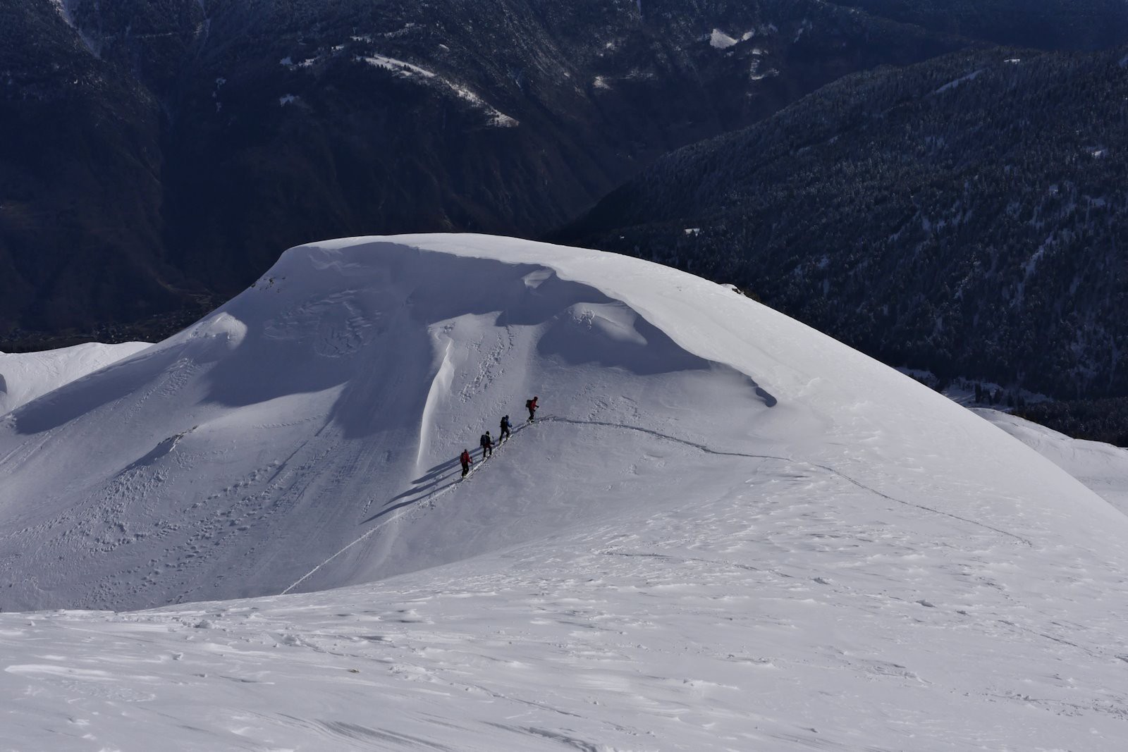 Un groupe de skieurs accède au sommet par la pente nord.
