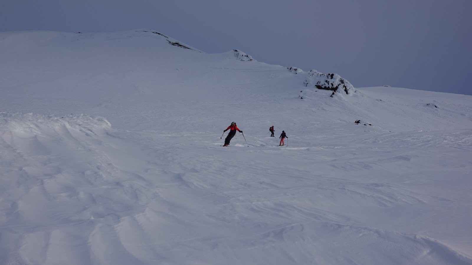 Début de descente à ski en neige dure lissée par le vent